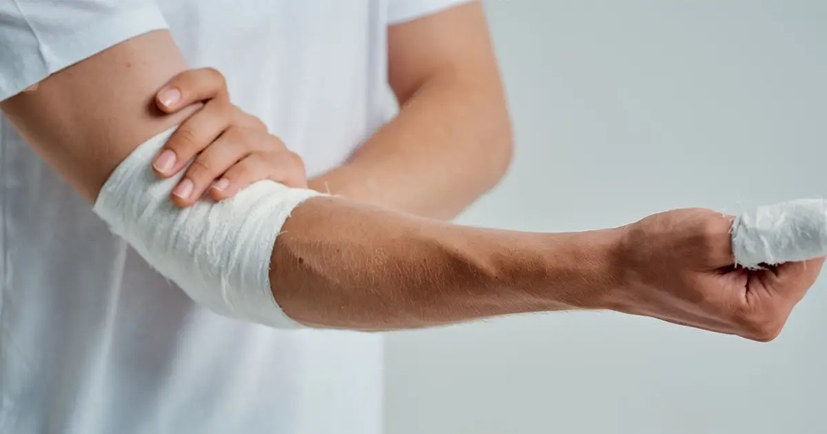 Person holding arm, bandaged arm and finger
