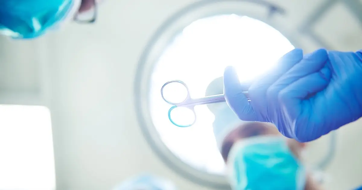 Surgeon handing over scissors during operation