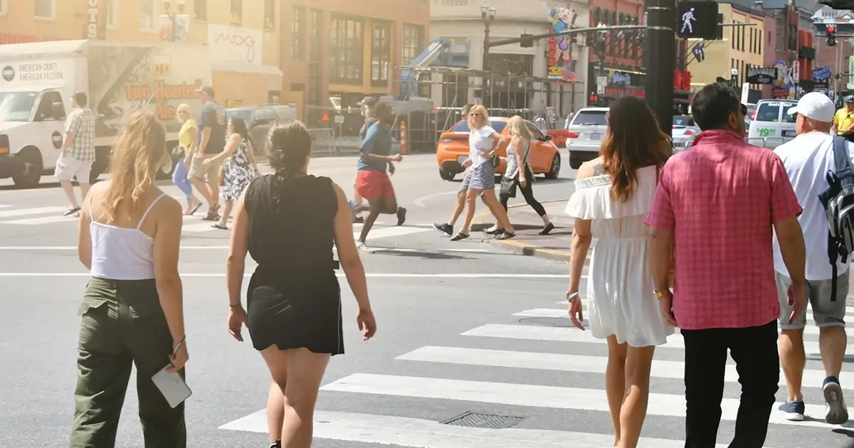 Many pedestrian crossing busy street